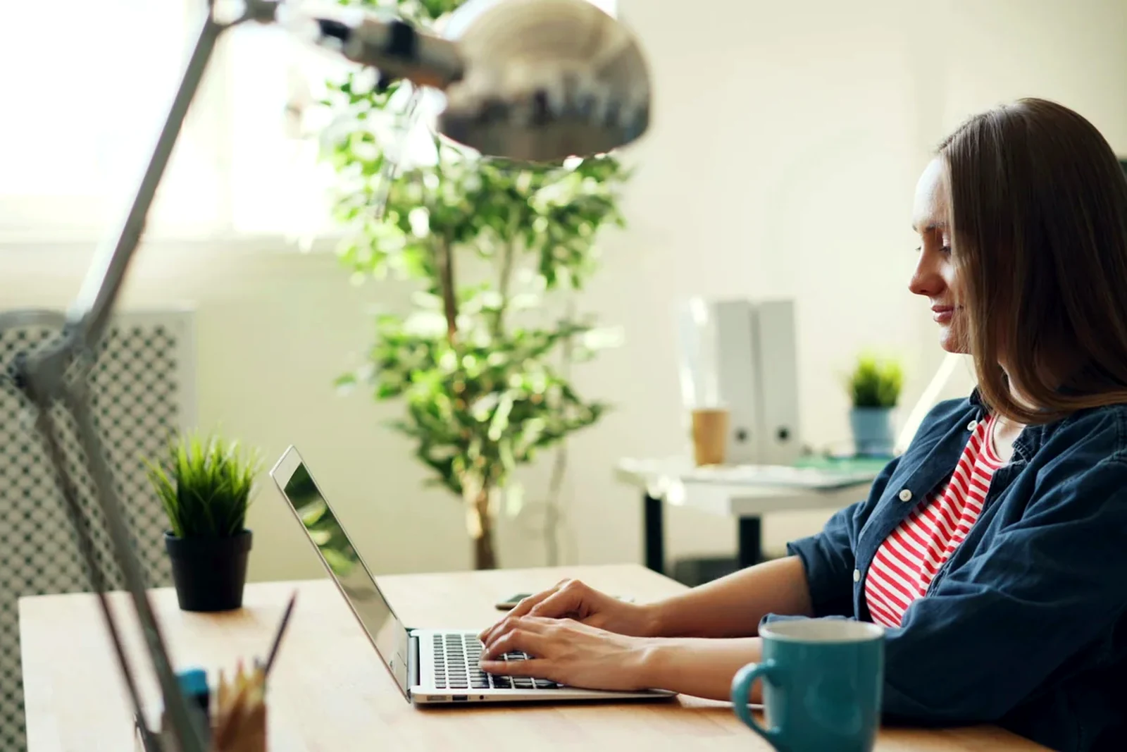 Freelancer working at a bright desk with a laptop while reviewing payment details.