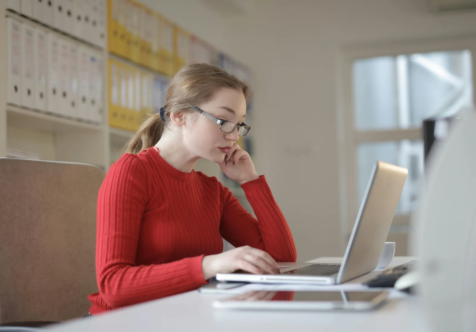 Freelancer working carefully from a bright office while preparing payment actions.