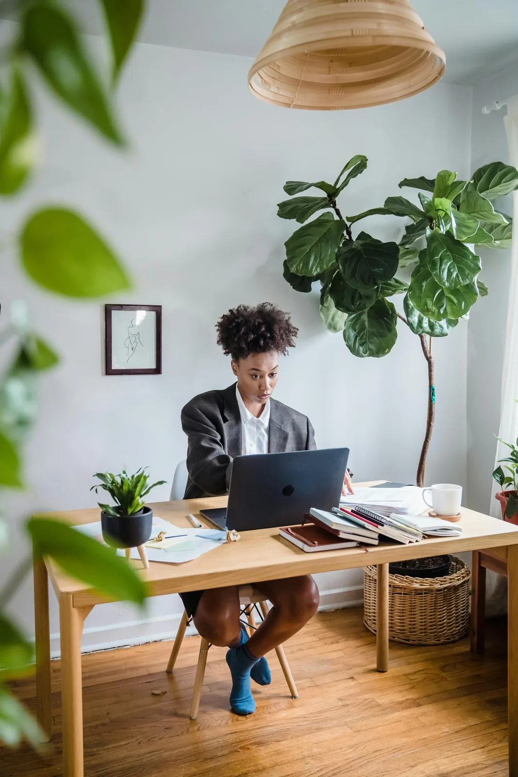 Professional working from a calm home office with a laptop and project notes on the desk.